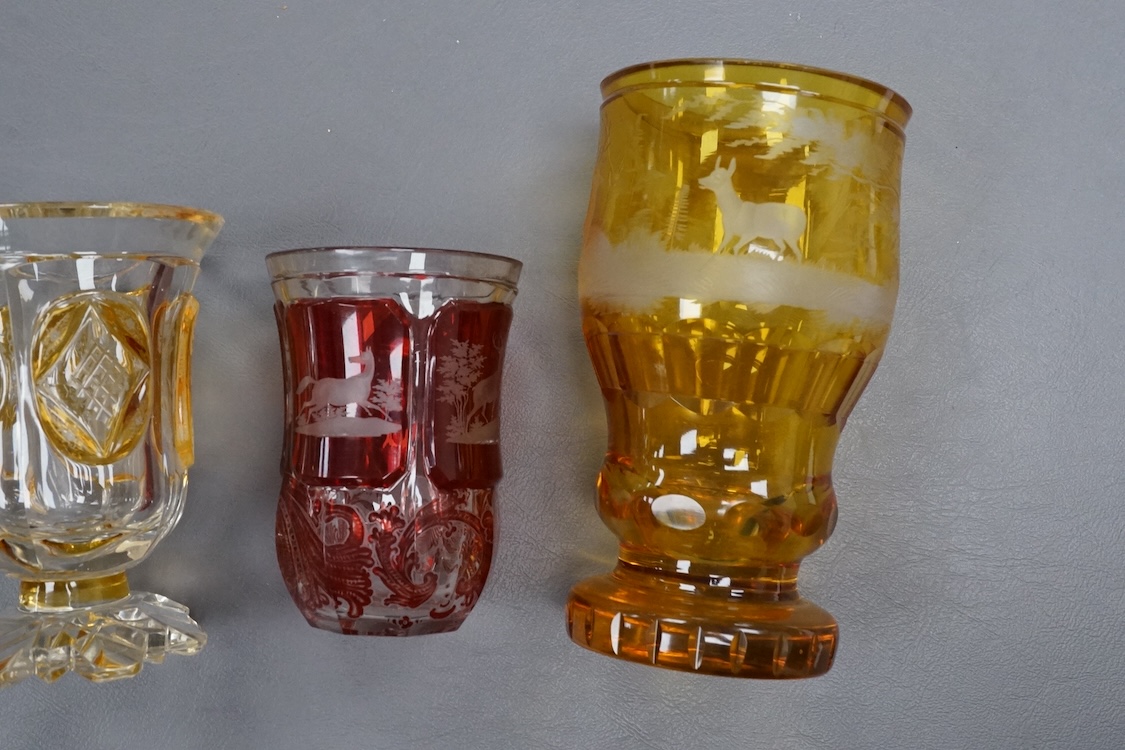 Four Bohemian engraved amber or ruby flashed ‘hunting’ goblets or beakers, late 19th century, tallest 15cm high